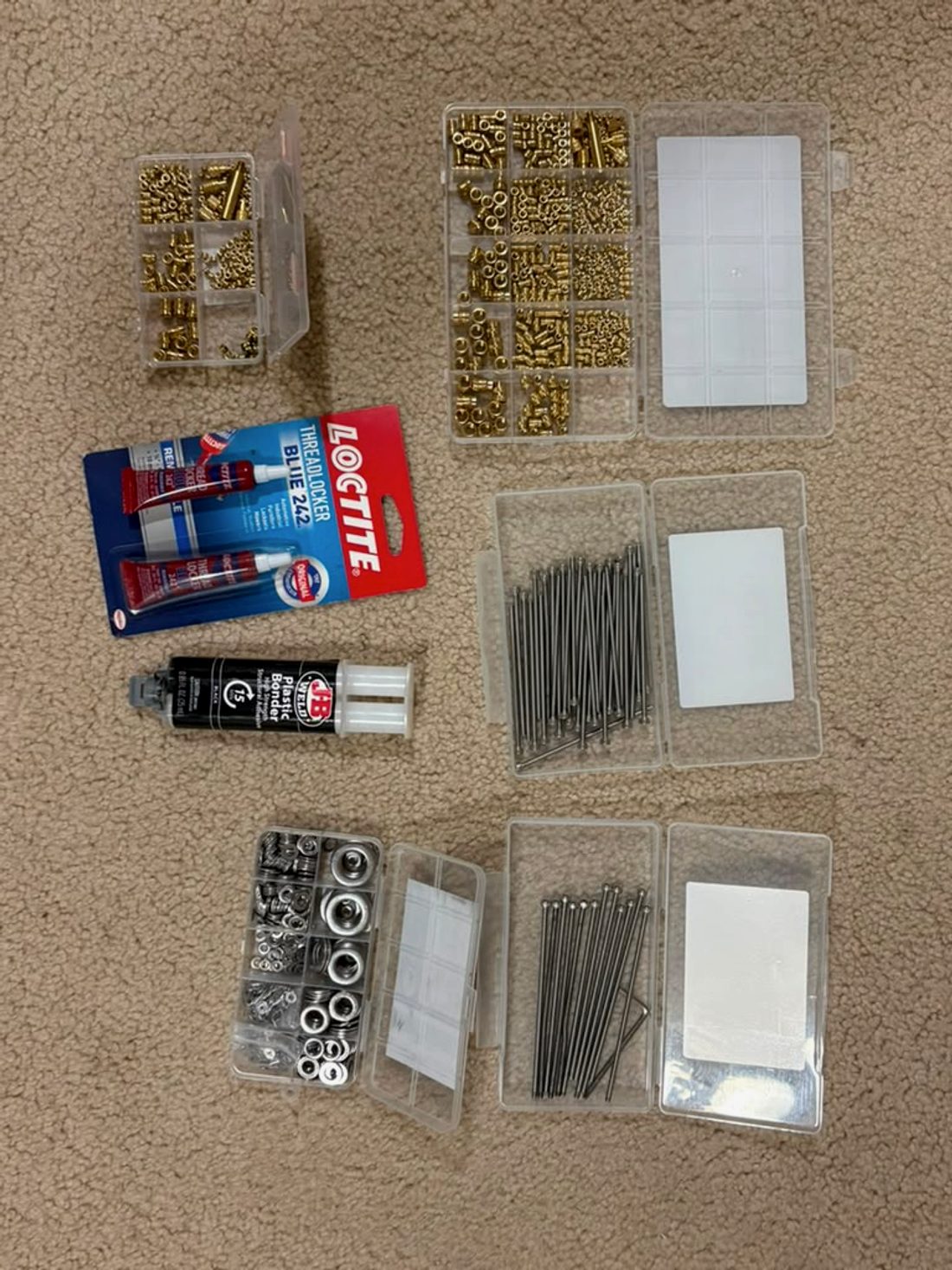 Sorted fastener trays, thread locker, and bonding adhesive laid out for the build